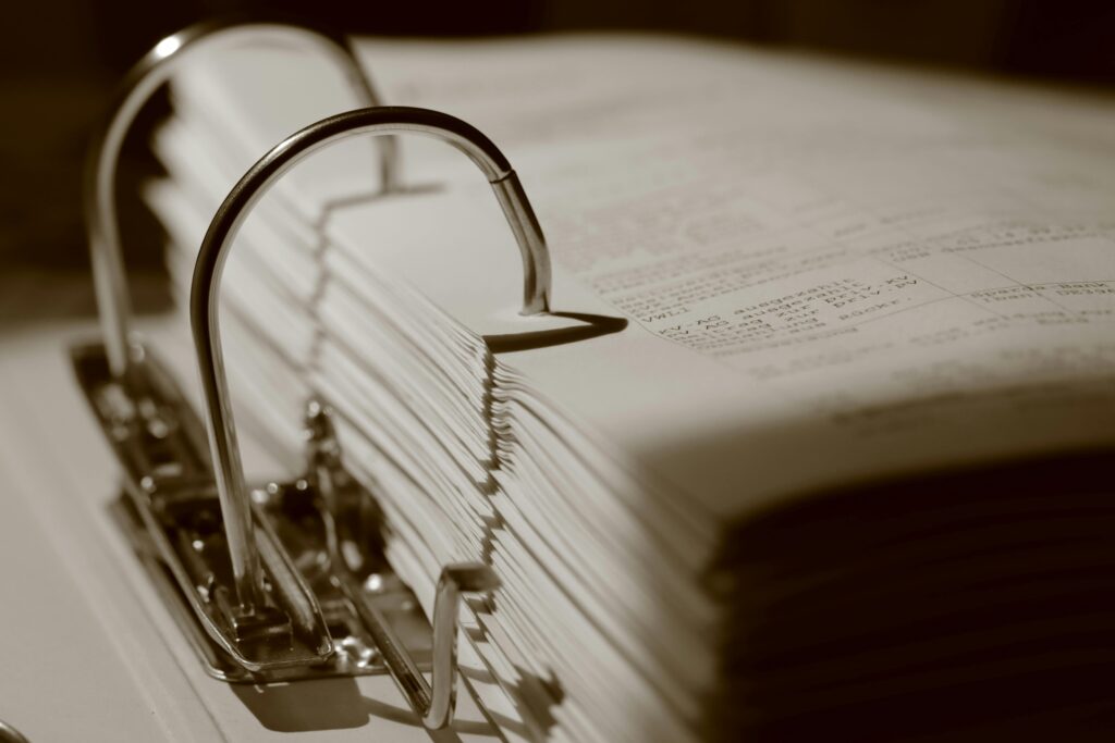 pexels photo 32201000 32201000 Detailed sepia close-up of a binder filled with documents, emphasizing texture.